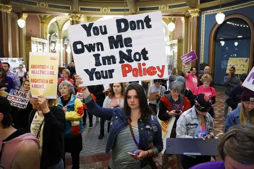 Marissa Messinger, of Lake View, Iowa, center, holds a sign during a rally to protest recent abortion bans, May 21, 2019, at the Statehouse in Des Moines, Iowa. The Iowa Supreme Court on Friday, June 17, 2022, cleared the way for lawmakers to severely limit or even ban abortion in the state, reversing a decision by the court just four years ago that guaranteed the right to the procedure under the Iowa Constitution. (AP Photo/Charlie Neibergall, File)
