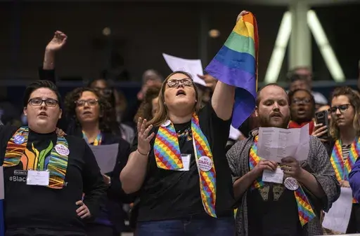Shelby Ruch-Teegarden, center, of Garrett-Evangelical Theological Seminary, joins other protestors during the United Methodist Church's special session of the general conference in St. Louis, Tuesday, Feb. 26, 2019. United Methodist rules forbid same-sex marriage rites and the ordination of “self-avowed practicing homosexuals,” but progressive Methodist churches in the U.S. have increasingly been defying these rules. (AP Photo/Sid Hastings, File)