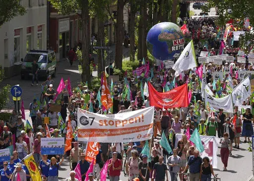 Climate activists and others hold banners and signs as they march during a demonstration ahead of a G-7 meeting in Munich, Germany, June 25, 2022. At this year's G-7 summit, Germany will push its plan for countries to join together in a ‘climate club' to tackle global warming.  (AP Photo/Matthias Schrader, File)