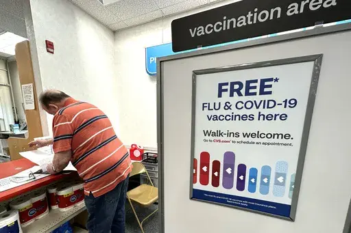 A sign for flu and covid vaccinations is displayed at a pharmacy store in Palatine, Ill., Wednesday, Sept. 13, 2023. The flu season in the U.S. is getting worse but it's too soon to tell how much holiday gatherings contributed to a likely spike in illnesses. New government data posted Friday, Jan. 5, 2024 for the previous week _ the holiday week between Christmas and New Year's _ show 38 states with high or very high levels for respiratory illnesses with fever, cough and other symptoms. That's u