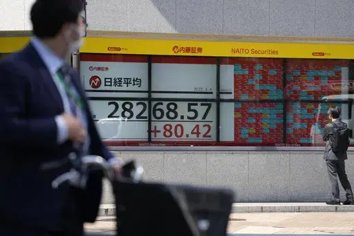 People look at an electronic stock board showing Japan's Nikkei 225 index at a securities firm Tuesday, April 4, 2023 in Tokyo. (AP Photo/Shuji Kajiyama)