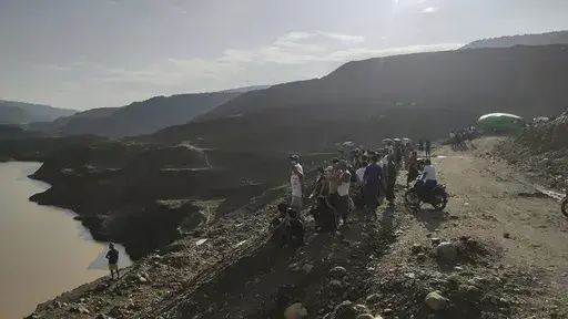 Miners, rescuers and local residents look at the jade mine site where a landslide accident took place in Hpakant township, Kachin state, Myanmar Sunday, Aug. 13, 2023. A landslide at the jade mine left scores of people missing, and a search and rescue operation was underway on Monday, a rescue official said. (AP Photo)
