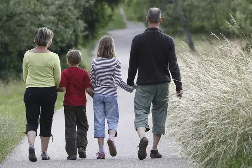 FILE -- This June 14, 2008 file photo shows a family walking through the fields in the village of Gaiberg, near Heidelberg, southwestern Germany. Germany’s justice minister has launched plans to relax the country’s strict restrictions on family names — for example, allowing couples to take double-barreled surnames and pass them on to their children. (AP Photo/Daniel Roland, file)