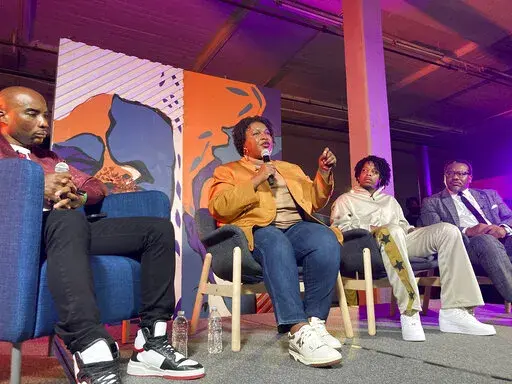 Georgia Democratic candidate for governor Stacey Abrams speaks at a campaign event on Friday, Sept. 9, 2022, in Atlanta, flanked by radio and TV personality Charlamagne tha God, left, rapper 21 Savage and civil rights lawyer Francys Johnson, right. The event is one of a series that Abrams has done to appeal to Black men in her race against Republican incumbent Brian Kemp. (AP Photo/Jeff Amy)