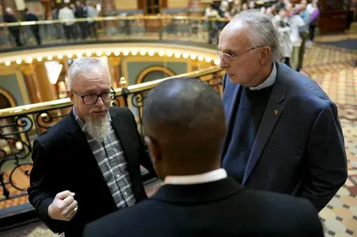Rev. Mike Demastus, of Des Moines, Iowa, left, and Rev. Bob Curry, of Johnston, Iowa, right, talk with State Rep. Eddie Andrews, center, Thursday, April 6, 2023, at the Statehouse in Des Moines, Iowa. (AP Photo/Charlie Neibergall)