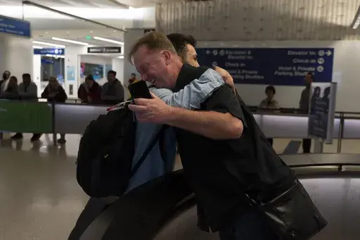 Michael White, a Navy veteran who was jailed in Iran for several years on spying charges, right, hugs Michael's former fellow prisoner and Iranian political activist Mahdi Vatankhah at the Los Angeles International Airport in Los Angeles, Thursday, June 1, 2023. Vatankhah, while in custody and after his release, helped White by providing White's mother with crucial, firsthand accounts about her son's status in prison and by passing along letters White had written while he was locked up. Once fre