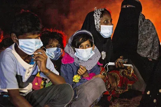 Ethnic Rohingya women and children sit by a fire on a beach after their boat was stranded on Idaman Island in East Aceh, Indonesia, late Friday, June 4, 2021, after leaving a refugee camp in Bangladesh, officials said. U.S. officials say the Biden administration intends to declare that Myanmar's years-long repression of the Rohingya Muslim population is a “genocide.” Two officials say Secretary of State Antony Blinken plans to announce the long-anticipated designation on Monday, March 21, 20