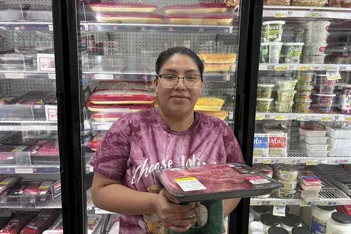 Jasmine Acosta, 23, poses in front of the meat aisle at a Smart & Final grocery store in Los Angeles. (AP Photo/Jaimie Ding)