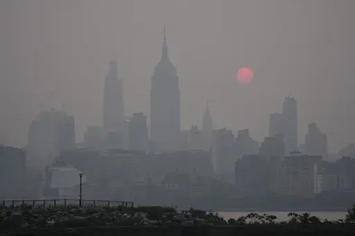 The sun rises over a hazy New York City skyline as seen from Jersey City, N.J., Wednesday, June 7, 2023. (AP Photo/Seth Wenig)