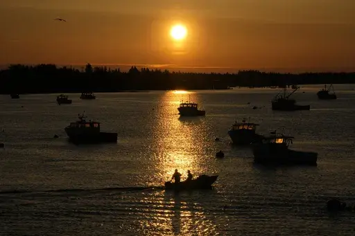 Lobstermen motor out to their moored fishing boat in Jonesport, Maine, Thursday, April 28, 2023. The fishing industry is a major employer in the rural area where a local family wants to build the world's tallest flagpole. Situated at the nation’s eastern tip, Maine’s Down East region is the place where the sunlight first kisses U.S. soil each day. (AP Photo/Robert F. Bukaty)