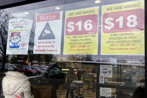 Hiring signs are displayed at a grocery store in Arlington Heights, Ill., Jan. 13, 2023. Employers are increasingly posting salary ranges for job openings, even in states where it's not mandated by law, according to analysts with employment sites Indeed, GlassDoor, and Monster. (AP Photo/Nam Y. Huh, File)