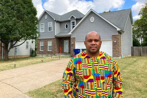 Abdul-Kaba Abdullah stands in front of his former home in St. Louis on Friday, Oct. 7, 2022. Abdullah sold the home two years ago for less than he thought it was worth after an appraisal came in lower than expected. He believes the appraisal was low because the home is in north St. Louis, a predominantly Black area of the city. St. Louis is among several U.S. cities where realtors have recently apologized for past housing discrimination and announced new efforts to protect housing rights. (AP Ph