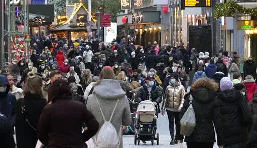 People wear mandatory face masks walk along a street in Dortmund, Germany, Dec. 1, 2021. Inflation in the 19 countries that use the euro currency hit a new high of 5.0% in December, breaking the record set the previous month. (AP Photo/Martin Meissner, File)