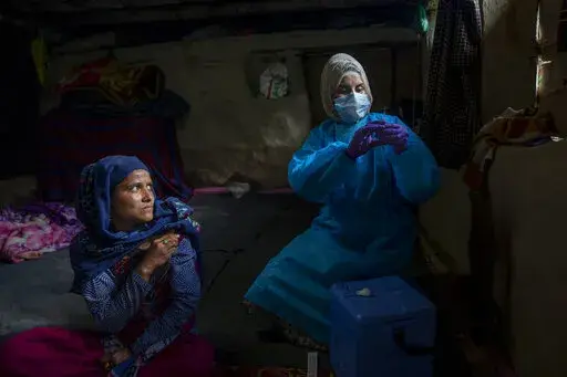 Masrat Farid, a healthcare worker, prepares to administer a dose of Covishield vaccine to Rubia Begum inside a hut during a COVID-19 vaccination drive in Gagangeer, northeast of Srinagar, Indian controlled Kashmir on June 22, 2021. Farid has traveled long distances to vaccinate mostly shepherds and nomadic herders in the remote meadows of the Himalayan region of Indian-controlled Kashmir. (AP Photo/Dar Yasin)