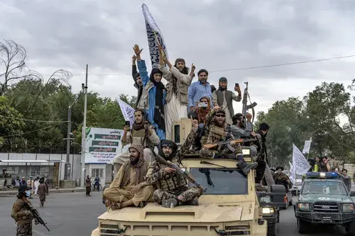 Taliban fighters celebrate one year since they seized the Afghan capital, Kabul, in front of the U.S. Embassy in Kabul, Afghanistan, Monday, Aug. 15, 2022. (AP Photo/Ebrahim Noroozi, File)