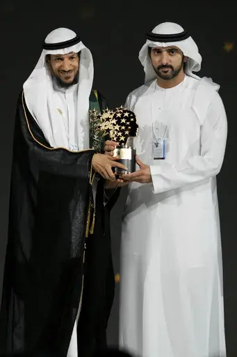 Saudi Arabian teacher Mansour bin Abdullah Al-Mansour, left, receives the Global Teacher Prize trophy from Dubai Crown Prince Sheikh Hamdan bin Mohammed Al Maktoum at a ceremony awarding the Global Teacher Prize in Dubai, United Arab Emirates, Thursday, Feb. 13, 2025. (AP Photo/Altaf Qadri)