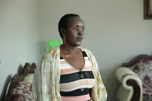 Achut Deng, a refugee from South Sudan, poses in her home in Sioux Falls, S.D., on Sept. 17, 2022, before the release of her memoir, “Don’t Look Back.” Deng shared her experience of being sickened with COVID-19 alongside hundreds of her coworkers at a pork processing plant. She shares her story of fleeing massacres and surviving a refugee story in her book. (AP Photo/Stephen Groves)