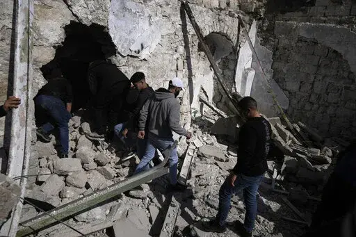 Palestinians inspect the ruins of a militant hideout destroyed during a raid by Israeli forces in the Old City of Nablus in the West Bank, Wednesday, Feb. 22, 2023. Israeli troops moved into the city, setting off fighting that killed several Palestinians, including a 72-year-old man, Palestinian health officials said. The Israeli military gave few details about its operation in the northern city, which is known as a militant stronghold, and the army frequently operates there. (AP Photo/Majdi Moh