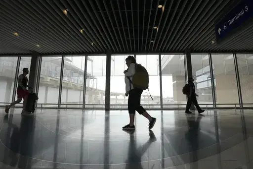 Carol Giuliani, who is a member of the Dementia-Friendly Airports Working group and works as a travel companion for seniors with dementia, walks through Terminal 3 at Phoenix Sky Harbor International Airport after bringing a client from Minnesota Wednesday, Aug. 23, 2023, in Phoenix. “Ninety percent of the time it’s a family member that hires me,” said Giuliani, while seated at Phoenix Sky Harbor after escorting an elderly man on a flight. “The one I did today, (the wife) was like ‘tha