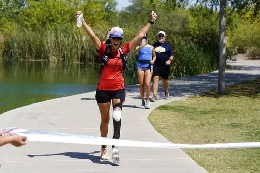 Jacky Hunt-Broersma finishes her 102nd marathon in 102 days, this one at Veterans Oasis Park, Thursday, April 28, 2022, in Chandler, Ariz. (AP Photo/Ross D. Franklin)