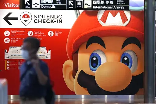 A traveler walks past an advertisement featuring a Nintendo character at Narita airport in Narita near Tokyo Friday, June 10, 2022. A Saudi sovereign wealth fund now holds 8.26% of the stock in the video game maker Nintendo, making it the largest outside investor in the Japanese gaming company, a company filing said Friday, Feb. 17, 2023. (AP Photo/Shuji Kajiyama, File)