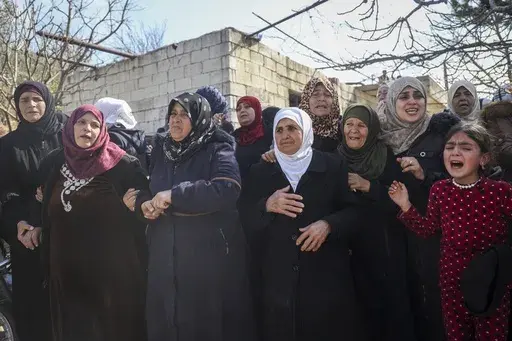 Relatives and neighbours mourn during the funeral procession for four Syrian security force members killed in clashes with loyalists of ousted President Bashar Assad in coastal Syria, in the village of Al-Janoudiya, west of Idlib, Saturday, March 8, 2025. (AP Photo/Omar Albam)