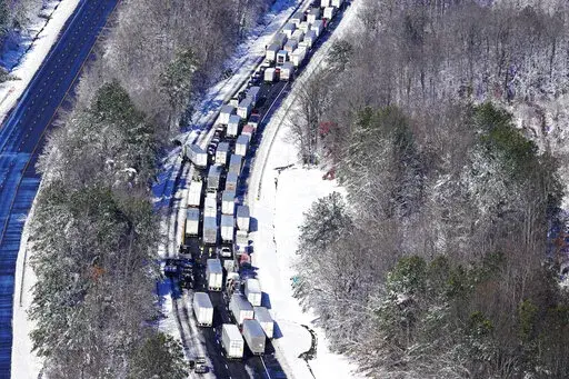 Drivers wait for the traffic to be cleared as cars and trucks are stranded on sections of Interstate 95 Tuesday Jan. 4, 2022, in Carmel Church, Va. Close to 48 miles of the Interstate was closed due to ice and snow. (AP Photo/Steve Helber)