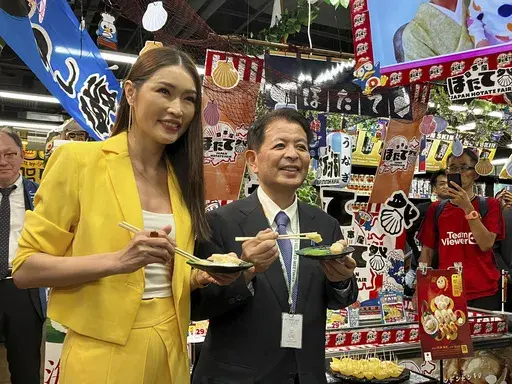 Japanese Agriculture Minister Ichiro Miyashita, right, and Malaysian celebrity Amber Chia attend an event at Japanese store, Don Don Donki in Kuala Lumpur Wednesday, Oct. 4, 2023 to promote the safety and deliciousness of Japanese scallops to shoppers. Japan hopes to resolve the issue of China's ban on its seafood within the scope of the World Trade Organization ambit and will hold food fairs overseas to bolster seafood exports amid safety concerns over the release of treated water from the Fuku