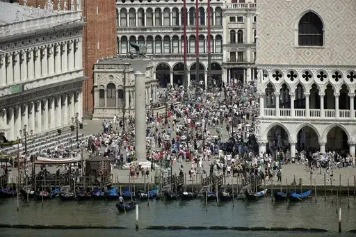 A view of the St. Mark's Square in Venice, Italy, taken on June 8, 2019. Venice authorities have rolled out a pilot program to charge day-trippers 5 euros ($5.45) apiece to enter the fragile lagoon city on peak weekends next year. The aim is to reduce crowds, encourage longer visits and improve the quality of life for residents. (AP Photo/Luca Bruno, File)