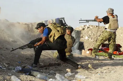 In this Monday, June 15, 2015, Iraqi security forces defend their positions against an Islamic State group attack in Husaybah, 8 kilometers (5 miles) east of Ramadi, Iraq. (AP Photo, File)