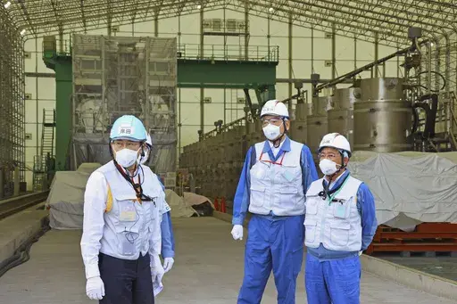 Japanese Prime Minister Fumio Kishida, left, along with Tomoaki Kobayakawa, president of Tokyo Electric Power Co. (TEPCO), second right, and Yoshimitsu Kobayashi, chairman of TEPCO, visits a facility to treat radioactive wastewater at the tsunami-wrecked Fukushima Daiichi nuclear power plant in Okuma town, northeastern Japan, Sunday, Aug. 20, 2023. Kishida made a brief visit to the power plant on Sunday to highlight the safety of an impending release of treated radioactive wastewater into the Pa