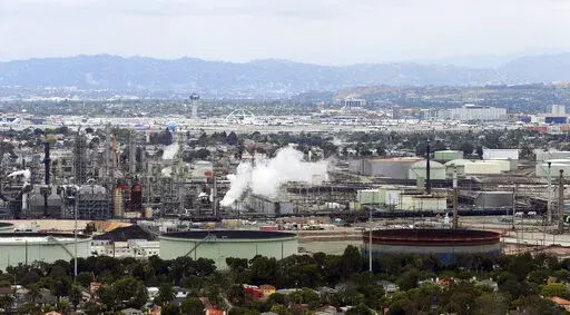 This aerial photo shows the Standard Oil Refinery in El Segundo, Calif., with Los Angeles International Airport in the background and the El Porto neighborhood of Manhattan Beach, Calif., in the foreground on May 25, 2017. California air regulators are set to approve an ambitious plan for the state to achieve carbon neutrality by 2045. Doing so will require a rapid transition away from oil and gas and toward renewable energy to power everything from cars to buildings. (AP Photo/Reed Saxon, File)