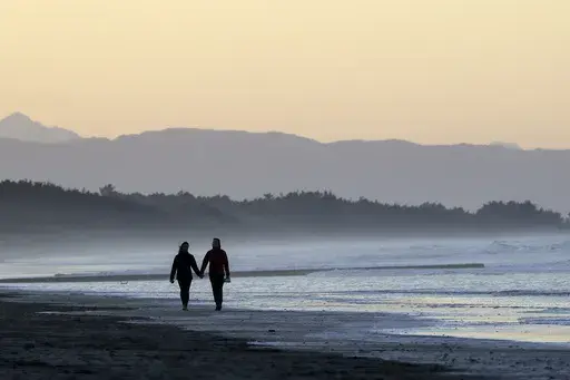 A couple walk along New Brighton Beach at sunset in Christchurch, New Zealand, Tuesday, June 9, 2020. Contrary to popular belief, estate planning isn’t just for older adults or the wealthy, as unexpected circumstances can affect anyone regardless of age or financial status. (AP Photo/Mark Baker, File)