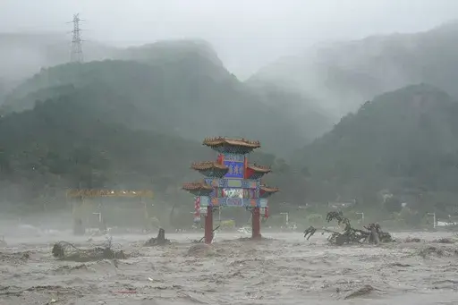 A traditional gate is seen inundated by flood waters in the Miaofengshan area on the outskirts of Beijing, Tuesday, Aug. 1, 2023. Chinese state media report some have died and others are missing amid flooding in the mountains surrounding the capital Beijing. (AP Photo/Ng Han Guan)