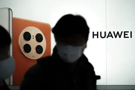 Visitors walk past the Huawei booth during the Mobile World Congress 2023 in Barcelona, Spain, Monday, Feb. 27, 2023. The four-day show kicks off Monday in a vast Barcelona conference center. It is the world's biggest and most influential meeting for the mobile tech industry. (AP Photo/Joan Mateu Parra)