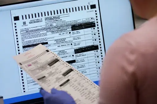 An election worker verifies a ballot on a screen inside the Maricopa County Recorders Office, Nov. 10, 2022, in Phoenix. On Friday, June 2, 2023, The Associated Press reported on stories circulating online incorrectly claiming newly released video shows election officials in Arizona’s Maricopa County illegally conducting “secret” voting equipment tests ahead of last November’s contested midterms. (AP Photo/Matt York, File)