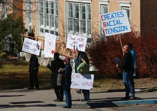 People protest outside the offices of the New Mexico Public Education Department's office, on Nov. 12, 2021, in Albuquerque, N.M. As conservative-run states across the U.S. move to restrict discussion of race, gender, and identity in the classroom, progressive-run states are trying to prioritize those discussions. In New Mexico, education officials are moving forward with a social studies curriculum that increases focus on identity, race and "privilege or systemic inequity." (AP Photo/Cedar Atta