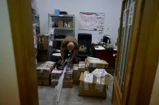 A volunteer prepares boxes of goods to be delivered to soldiers fighting on the eastern and southern fronts, dispatched from an NGO storage center in Kyiv, Ukraine, Monday, June 13, 2022. In the war in Ukraine, troops on both sides are getting supplies from crowd-funders. On the Ukrainian side, the self-starting networks of donors and volunteers are particularly large, spontaneous and well-oiled. At a critical juncture of the invasion, their deliveries of drones, high-tech optical gear, vehicles