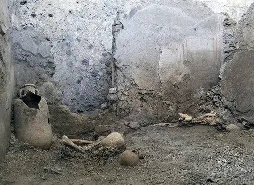 A picture made available Tuesday, May 16, 2023, by the Pompeii Archeological Park press office, showing two skeletons that archeologists believe were men who died when a wall collapsed on them during the powerful earthquakes that accompanied the eruption of Mount Vesuvius that destroyed the ancient city of Pompeii in the first century. The two skeletons were found in the insula of the Casti Amanti, beneath a wall that collapsed before the area was covered in volcanic material. (Pompeii Archeolog