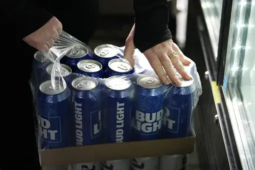 A stadium worker opens a case of Bud Light beer before a baseball game between the Philadelphia Phillies and the Seattle Mariners, Tuesday, April 25, 2023, in Philadelphia. (AP Photo/Matt Slocum)