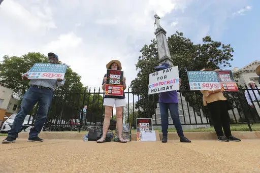 CORRECTS FACTUAL ERRORS AND REMOVES REFERENCE TO CONFEDERATE MEMORIAL DAY BEING NEW AS IT IS NOT NEW IN STATE LAW - Members of Indivisible Northeast Mississippi and Concerned Citizens protest Confederate Memorial Day in front of a Confederate monument at the old Lee County Courthouse in Tupelo Miss., Monday, April 25, 2022. The demonstrators called for an end to Confederate Heritage Month and Confederate Memorial Day. (Thomas Wells/The Northeast Mississippi Daily Journal via AP)