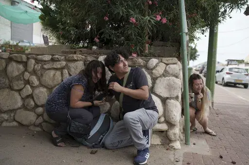 Israelis take cover from the incoming rocket fire from the Gaza Strip in Ashkelon, southern Israel on Oct. 11, 2023. (AP Photo/Leo Correa, File)