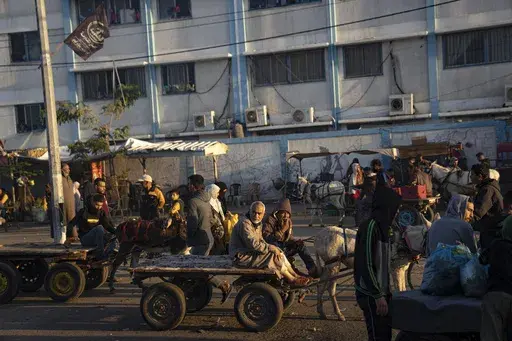 Palestinians ride donkey carts during the ongoing Israeli bombardment of the Gaza Strip in Khan Younis on Friday, Nov. 17, 2023. (AP Photo/Fatima Shbair)