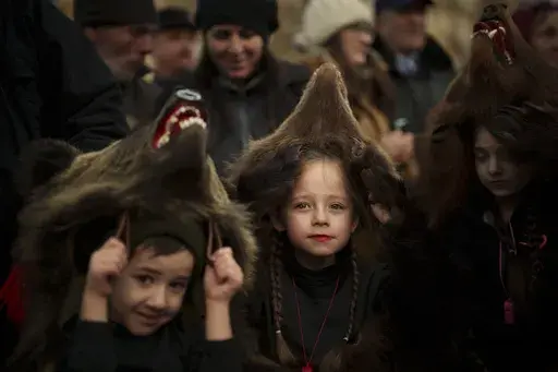 Sofia, 6 years-old, center, a members of a traditional bear pack takes part in a parade before performing in a festival in Moinesti, northern Romania, Wednesday, Dec. 27, 2023. Centuries ago, people in what is now northeastern Romania would don bear fur and dance to fend off evil spirits. Nowadays, the unique custom thrives, with popular festivals drawing large crowds of locals and tourists. (AP Photo/Vadim Ghirda)