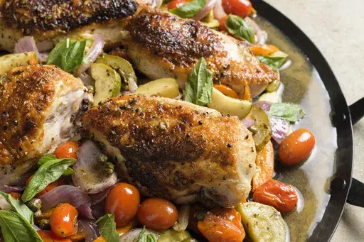 This image released by Milk Street shows a recipe for pan-roasted chicken and summer vegetables. (Milk Street via AP)