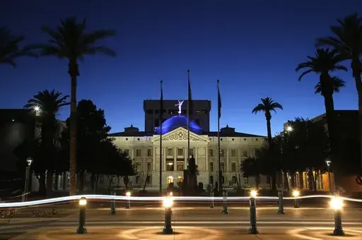 The blur of car lights zip past the Arizona Capitol as the dome is illuminated on April 15, 2020, in Phoenix. Social media users are falsely suggesting Arizona lawmakers have brought criminal charges against the state’s sitting governor. But no such indictment has been issued, and the state legislature isn’t authorized to issue such formal accusations of criminal wrongdoing in the first place. (AP Photo/Ross D. Franklin, File)