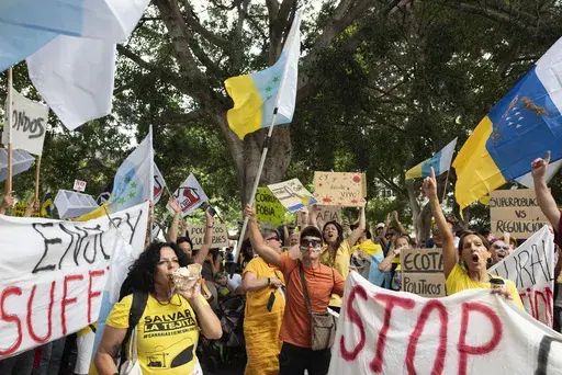People march during a mass demonstration against over tourism, which affects the local population with inaccessible housing, among other things, in Santa Cruz de Tenerife, Spain, April 20, 2024. (AP Photo/Miguel Velasco Almendral, file)