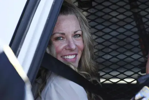 Lori Vallow Daybell sits in a police car after a hearing at the Fremont County Courthouse in St. Anthony, Idaho, on Aug. 16, 2022. A mother charged with murder in the deaths of her two children is set to stand trial in Idaho. The proceedings against Lori Vallow Daybell beginning Monday, April 3, 2023, could reveal new details in the strange, doomsday-focused case. (Tony Blakeslee/East Idaho News via AP, Pool, File)