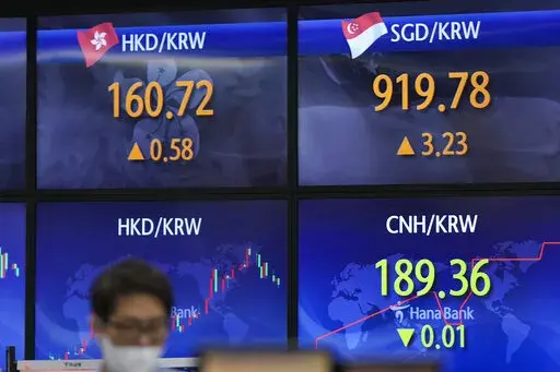 A currency trader stands near the screens showing the foreign exchange rates at a foreign exchange dealing room in Seoul, South Korea, Wednesday, May 25, 2022. Asian stock markets were mixed Wednesday after Wall Street sank on weak U.S. housing sales and a profit warning by a prominent social media brand. (AP Photo/Lee Jin-man)