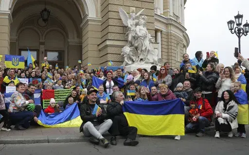 Ukrainians gather in downtown to celebrate the recapturing of Kherson city, Ukraine, Odesa, Saturday, Nov. 12, 2022. People across Ukraine awoke from a night of jubilant celebrating after the Kremlin announced its troops had withdrawn to the other side of the Dnieper River from Kherson, the only regional capital captured by Russia's military during the ongoing invasion. (AP Photo/Nina Lyashonok)